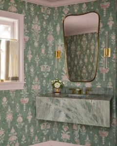 A powder room featuring fresh mint green wallpaper, beautifully reflected in the mirror.